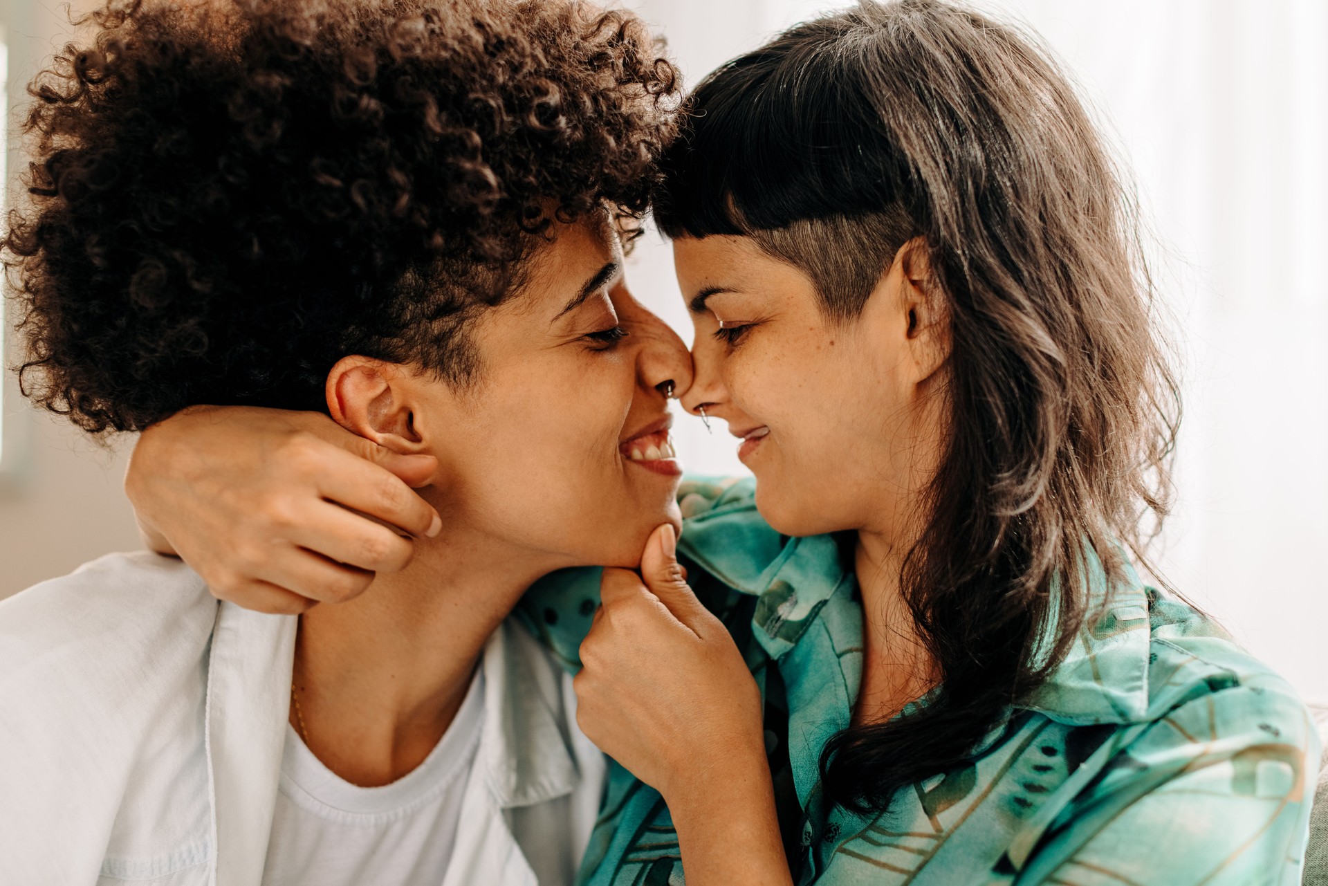 Playful lesbian couple touching their noses together
