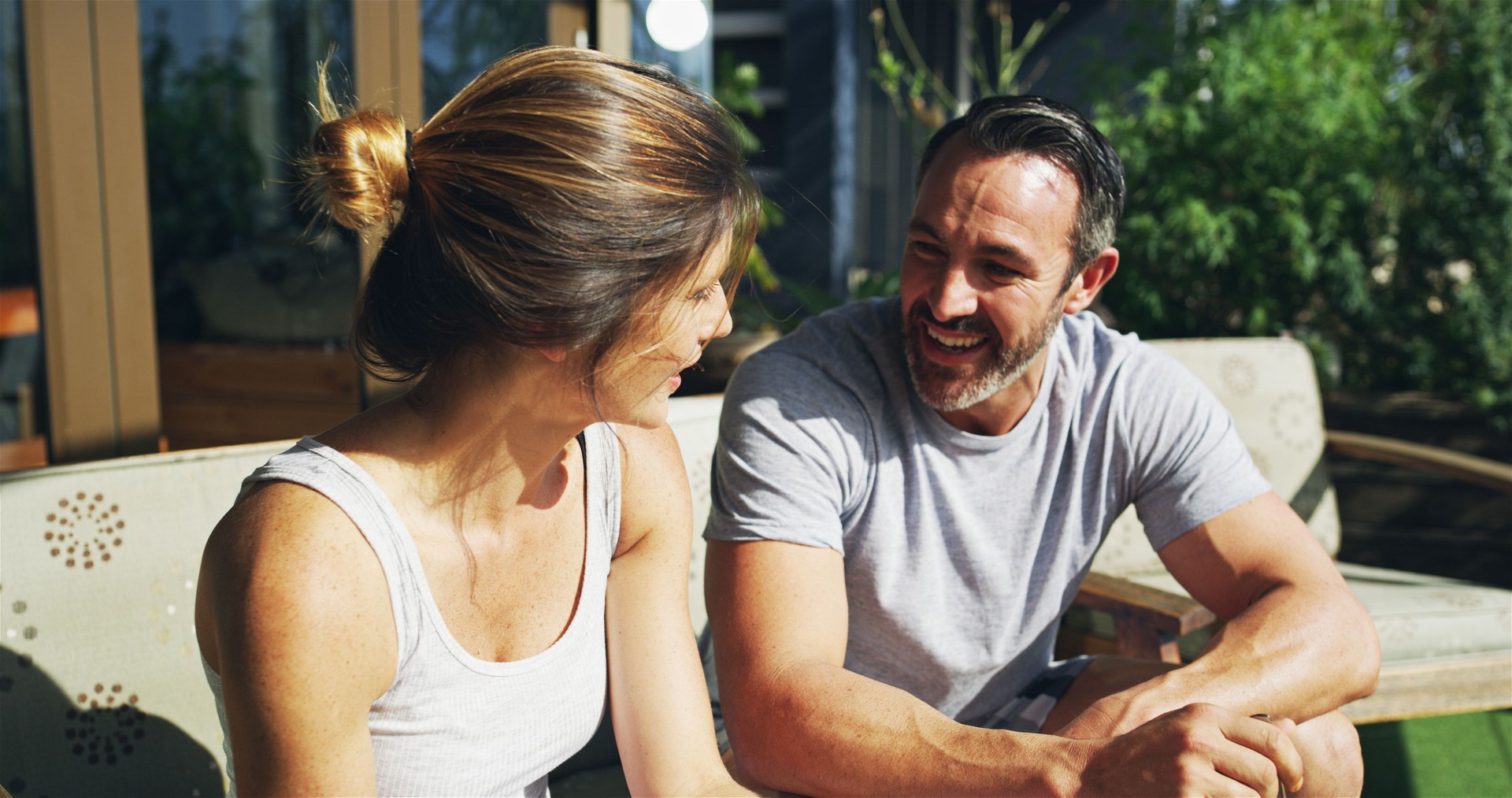 Relax, happy couple and talking outdoor for love, care and story on sofa in backyard by house. Mature man, woman and conversation together for relationship, connection or communication with partner